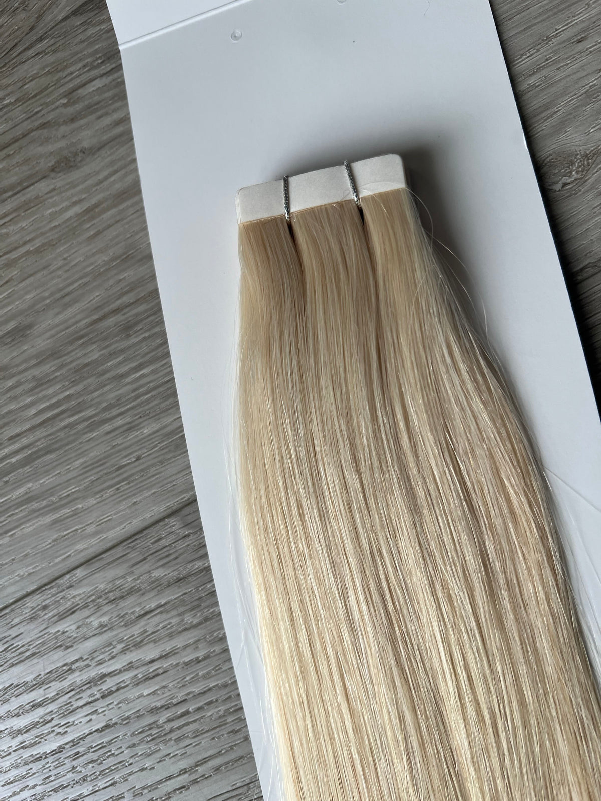 Medical-grade adhesive tape tabs close-up, platinum blonde #1001 tape in hair extensions